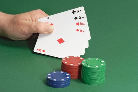 Poker chips with playing cards on green background