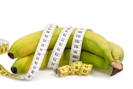Bananas with tape measure on bright backgorund