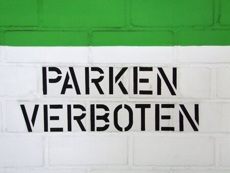 Parking prohibition on a white and green stone wallの写真素材