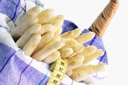 Fresh asparagus in a basket on bright backgroundの写真素材