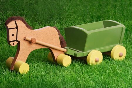 Horse wooden toy on green grass backgroundの写真素材