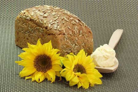 Bread with Oleo on a Cooking Spoon and Sunflowersの写真素材