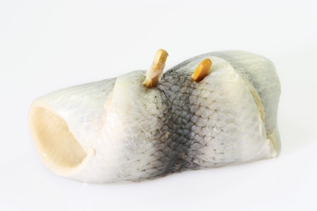 Rolled herring on bright background. Shot in studio.