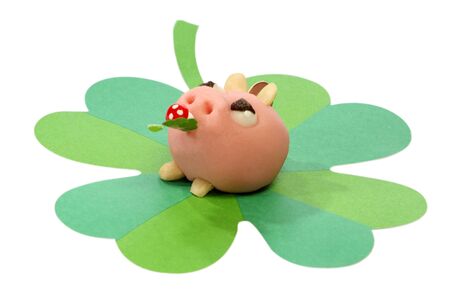 Lucky marzipan pig with cloverleaf and mushroom, on bright backgroundの写真素材
