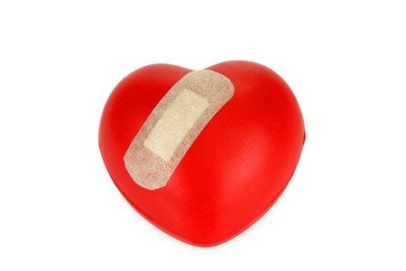 Red heart with plaster isolated on white backgroundの写真素材