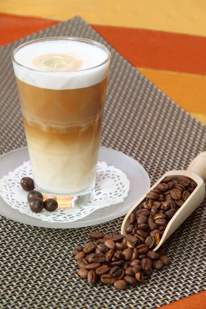 Latte Macchiato in glass with coffee grain on brown background
の写真素材