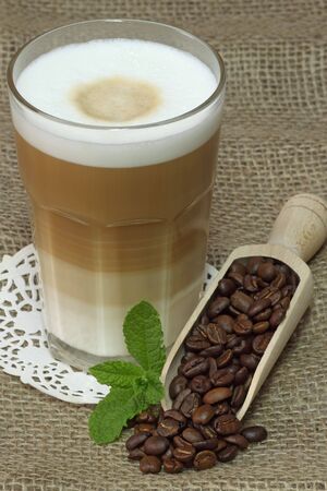 Latte Macchiato in glass with coffee grain on brown background
の写真素材