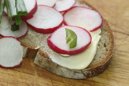 Fresh radish bread with spring leek as backgroundの写真素材