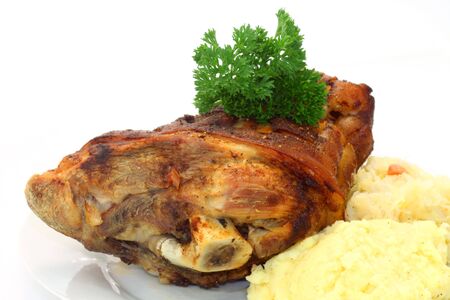 Bavarian roasted knuckle of pork with sauerkraut and mashed potatoes on bright backgroundの写真素材