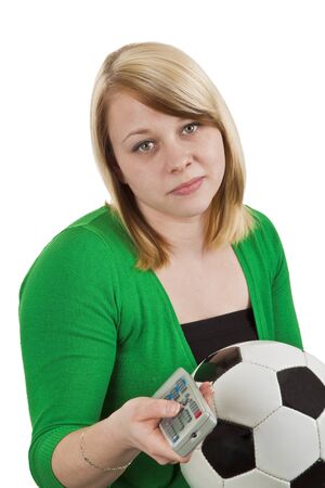 Young woman is zapping remote control by watching soccer matchesの写真素材