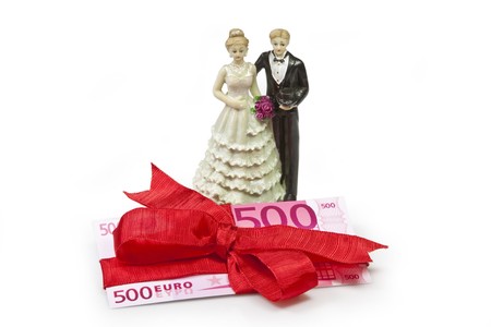 Bridal couple and  fivehundred Euro banknote wrapped with red ribbon as a giftの写真素材