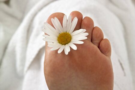 Foot with flower on white background.の写真素材