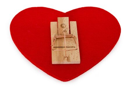 Mousetrap on red heart isolated on white backgroundの写真素材