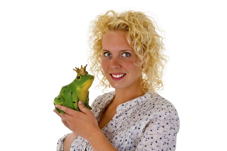 Young woman kissing a frog prince isolated on white backgroundの写真素材