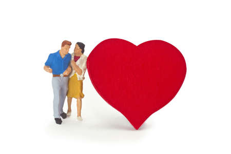 Figurine from senior couple with red heart on white backgroundの写真素材