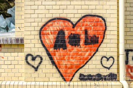 Red painted heart shape on a brick wall as backgroundの写真素材