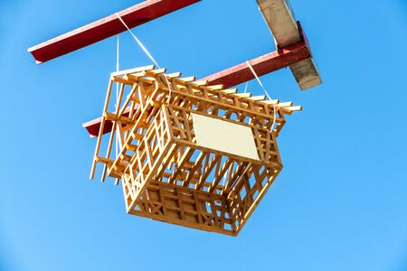 Marketing campaign with wooden house - hanging against blue sky