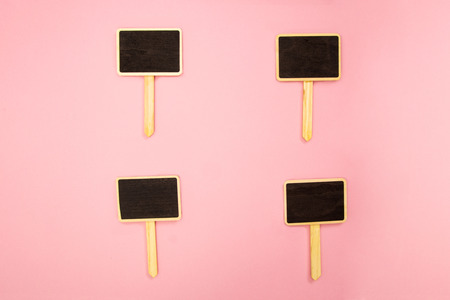 Four little blank chalkboards on pink paperの写真素材