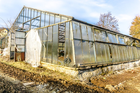 Greenhouse with broken glass, the construction is clearly visible.の写真素材