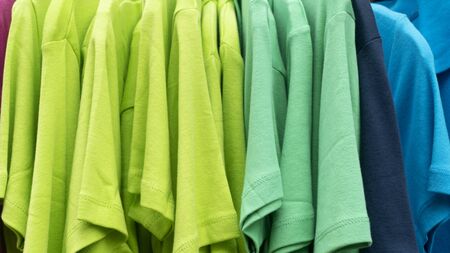 Shop offers colorful clothes in front of a shopの写真素材