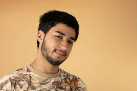 Beautiful black haired man on beige backgroundの写真素材