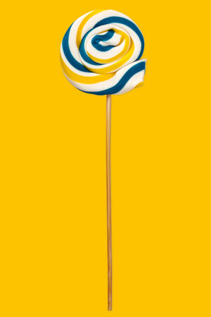 Sweet colorful lollipop isolated over yellow backgroundの写真素材