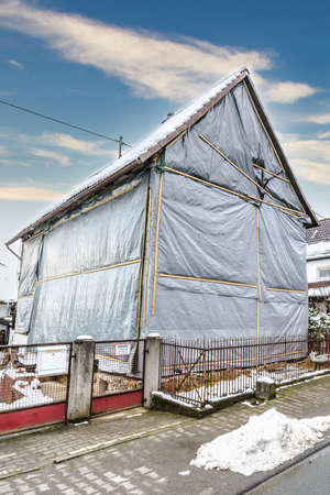 House covered with tarpaulin in winterの写真素材