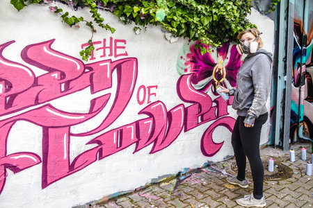WETZLAR, GERMANY - 23.05.2021: Young female artist doing artificial typography colorful graffiti senic on house facade in WETZLAR; GERMANYのeditorial素材
