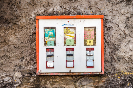 Huettenberg, Germany 2021-02-12: Old Vintage chewing gum machine hanging on a rough wall.のeditorial素材