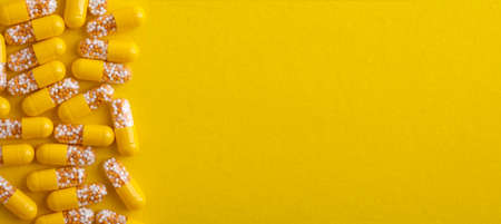 Top View from yellow pills over yellow backgroundの写真素材