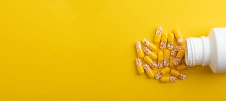 Panorama from Yellow Pills with a white pill box on yellow backgroundの写真素材