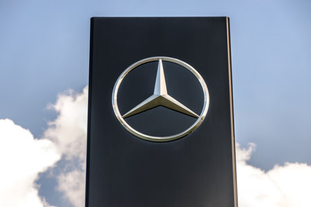 GIESSEN, GERMANY - 2021_04_09: Mercedes-Benz logo hanging on a modern advertising pillar. Mercedes-Benz is a global automobile brand and a division of the German DAX company Daimler.のeditorial素材
