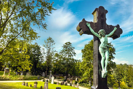 Jesus on the cross on a cemetery with blue sky in the summerの写真素材