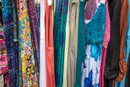 Colorful clothing hangin in front of a shopの写真素材