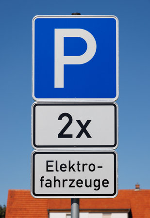 Parking sign for two electric vehicles on blue sky ready for charging.の写真素材