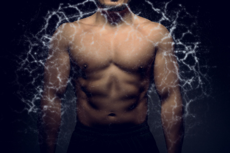 Perfect male upper body with electric energy. Concept of body transformation.