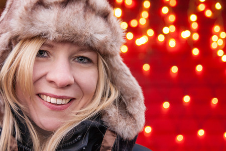 Attractive woman smiling and standing at a christmas marketの写真素材
