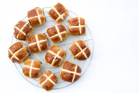 Freshly baked, Easter, hot cross buns on an isolated white background. View from above, looking...