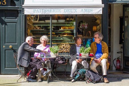 PARIS, FRANCE - MAY 5, 2016. Elderly tourists sitting at the outdoor tables of a small French patisserie or cafe on the streets of Paris.のeditorial素材