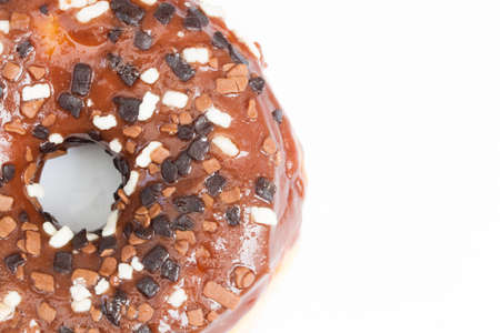 A large doughnut with chocolate icing and sprinkles on an isolated white background.の写真素材