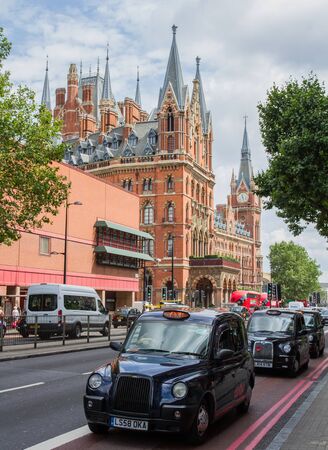 KING'S CROSS, LONDON, UK - JULY 21, 2016. Black London taxis queueing on the Euston Road with the Gothic architecture of St Pancras International train station in the background.のeditorial素材
