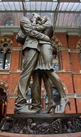 ST PANCRAS, LONDON, UK - JULY 21, 2016. The statue of an embracing couple known as The Meeting Place by the artist Paul Day greets rail passengers on their arrival at St Pancras International Train Station in London.のeditorial素材