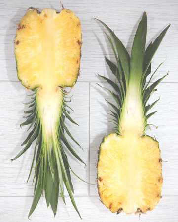 A sliced pineapple that is cut in half in a cross section and side by side in comparisonの写真素材