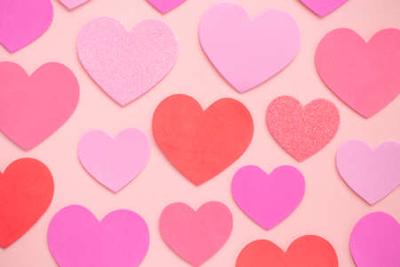 Looking down from above onto a pink and red love hearts on a pink background with copy space in a Valentine or romance celebration imageの写真素材