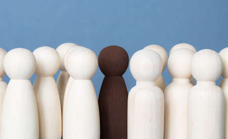 A Black Lives Matter concept of a black or Asian figure standing up for equality and diversity amongst the BAME community whilst amongst white peopleの写真素材