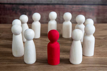 A business or social concept of generic figures grouped into a circle during a meeting, conference or forum discussing various topics with a leader or manager standing outの写真素材