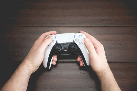 SELBY, UK, MARCH 11, 2021.  Close up of a pair of male hands using and playing with a Playstation...