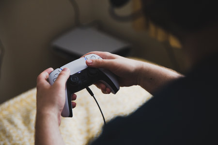 YORK, UK - MAY 9, 2021.  Close up of a teenage boy holding a PS5 gaming console controller whilst playing video gamesのeditorial素材
