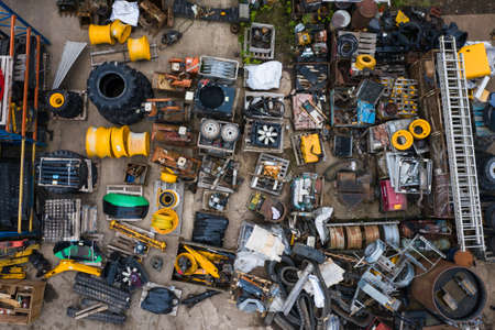 An aerial view looking down onto a scrapyard with scrap metal and vehicles with copy space