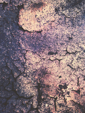 Full frame texture background of worn and weathered earth with a cracked and arid soil and a bronze brown hueの写真素材
